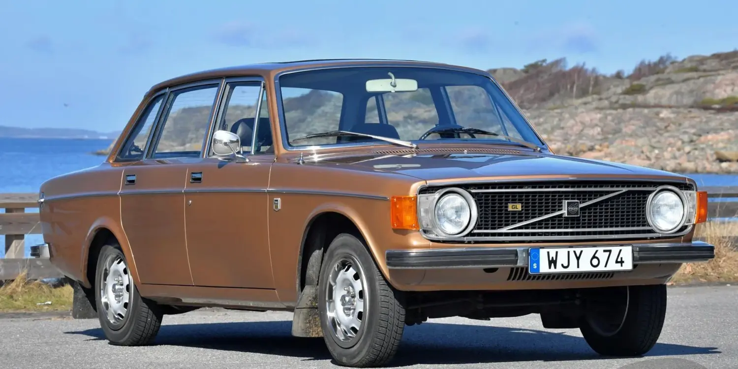 Brauner Volvo 144 GL B20 von 1973 geparkt vor Küstenkulisse