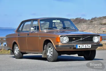 Brauner Volvo 144 GL B20 von 1973 geparkt vor Küstenkulisse