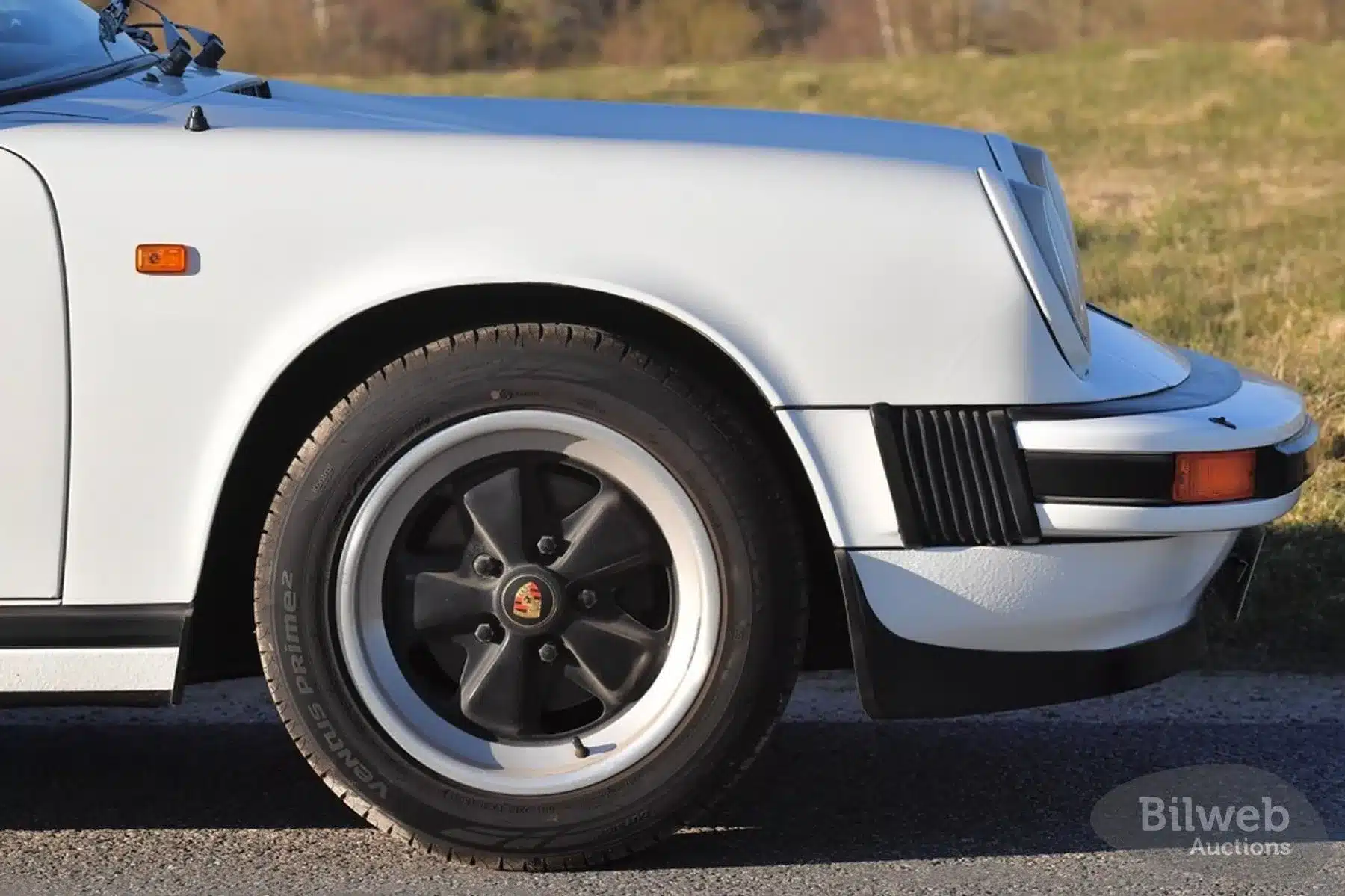 Detailaufnahme der Front und Vorderrad eines weißen Porsche 911 SC Targa 3,0 Baujahr 1981 mit originaler Fuchs-Felge