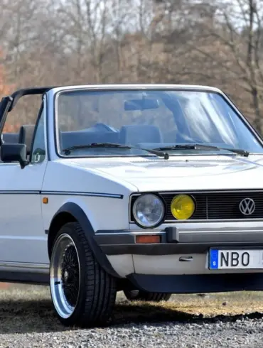 Weißes VW Golf Mk I Cabriolet von 1986 mit geöffnetem Verdeck und zeitgenössischer Patina, aufgenommen im Freien