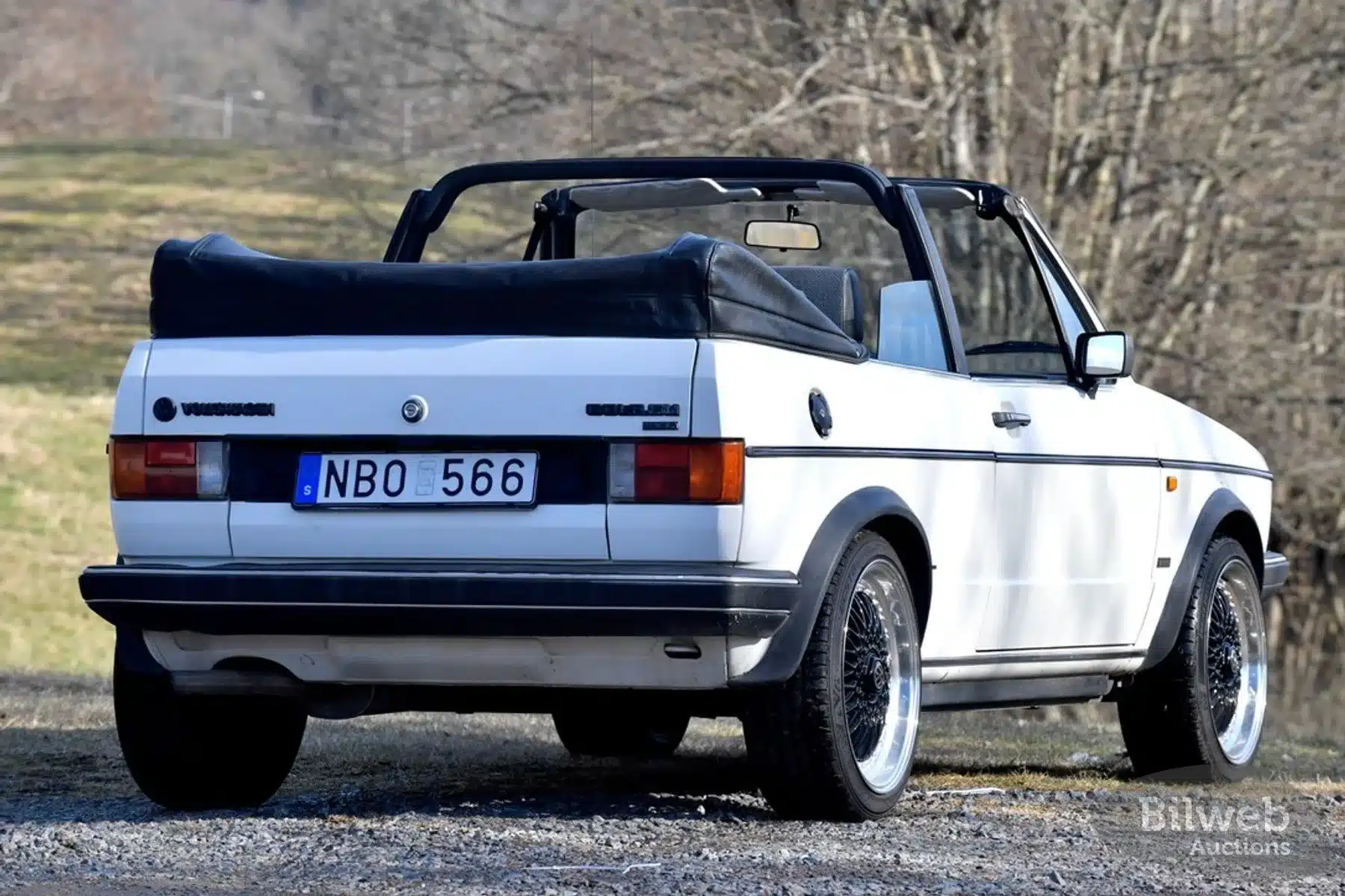 Weißes Volkswagen Golf 1 Cabriolet von 1986 mit offenem Verdeck, fotografiert von hinten auf einem Feldweg