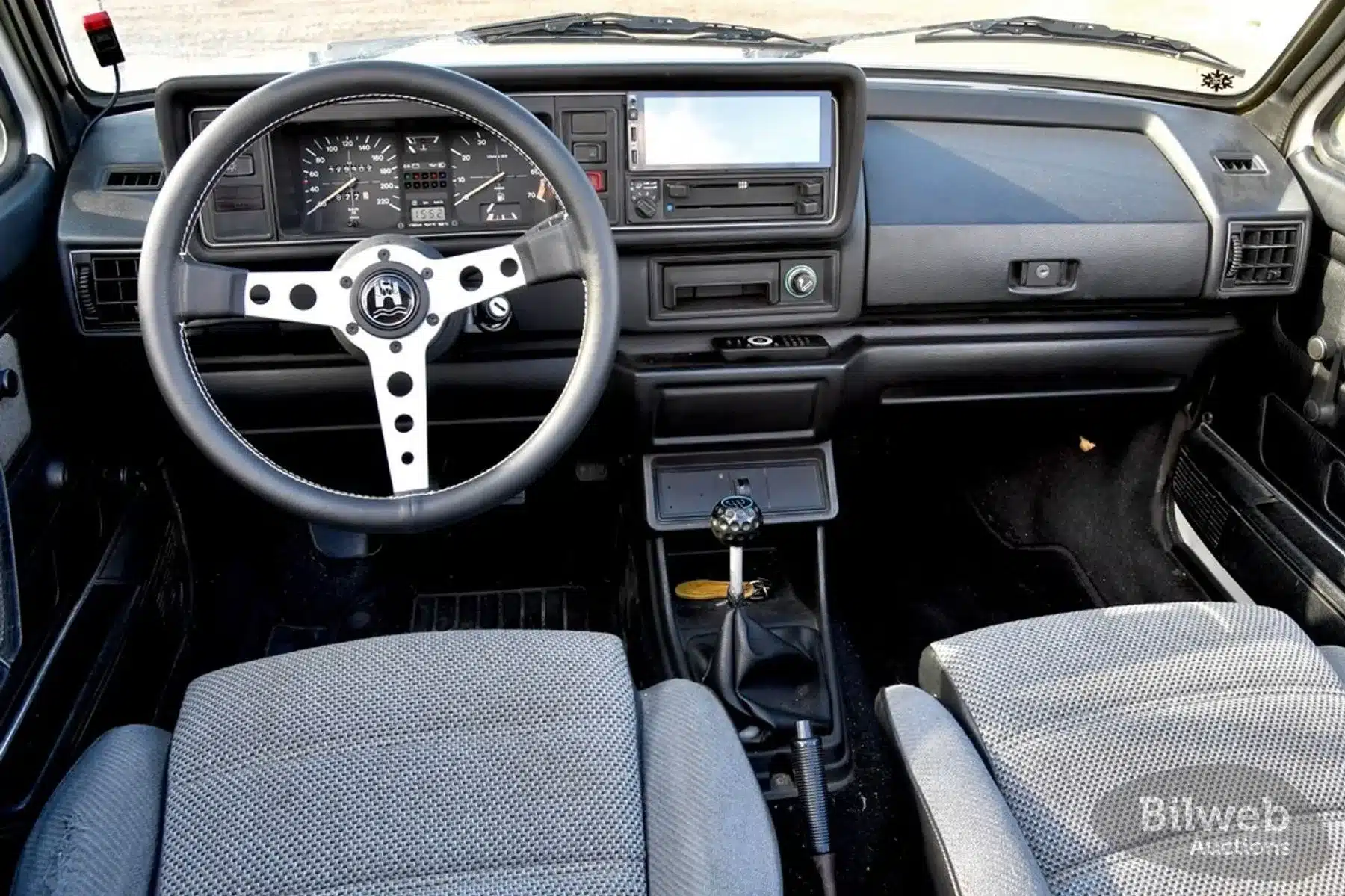 Innenraum eines Volkswagen Golf Mk I Cabriolet von 1986 mit klassischen Instrumenten, Sportsitze und Lenkrad.