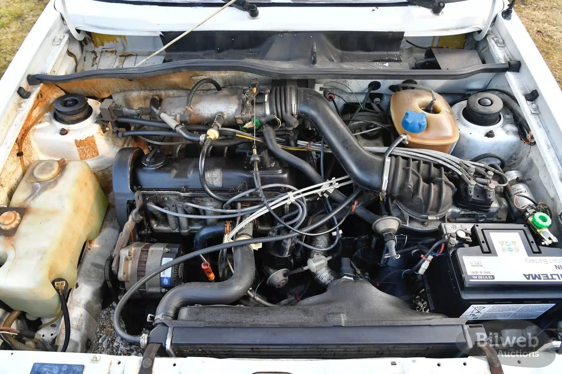 1,8-Liter-Motorraum eines Golf I Cabriolets von 1986 mit sichtbarer Patina und technischen Details.