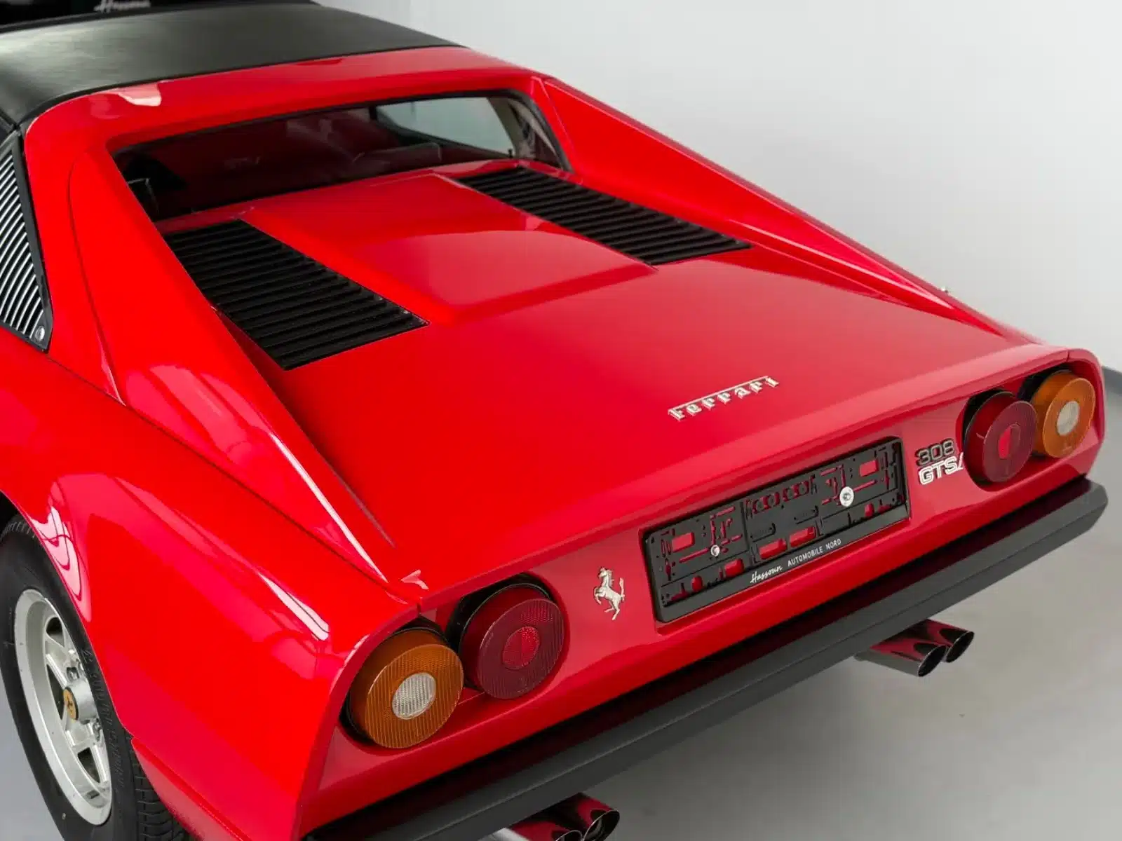 Heckansicht eines roten Ferrari 308 GTSi mit Targa-Dach und klassischen Rückleuchten