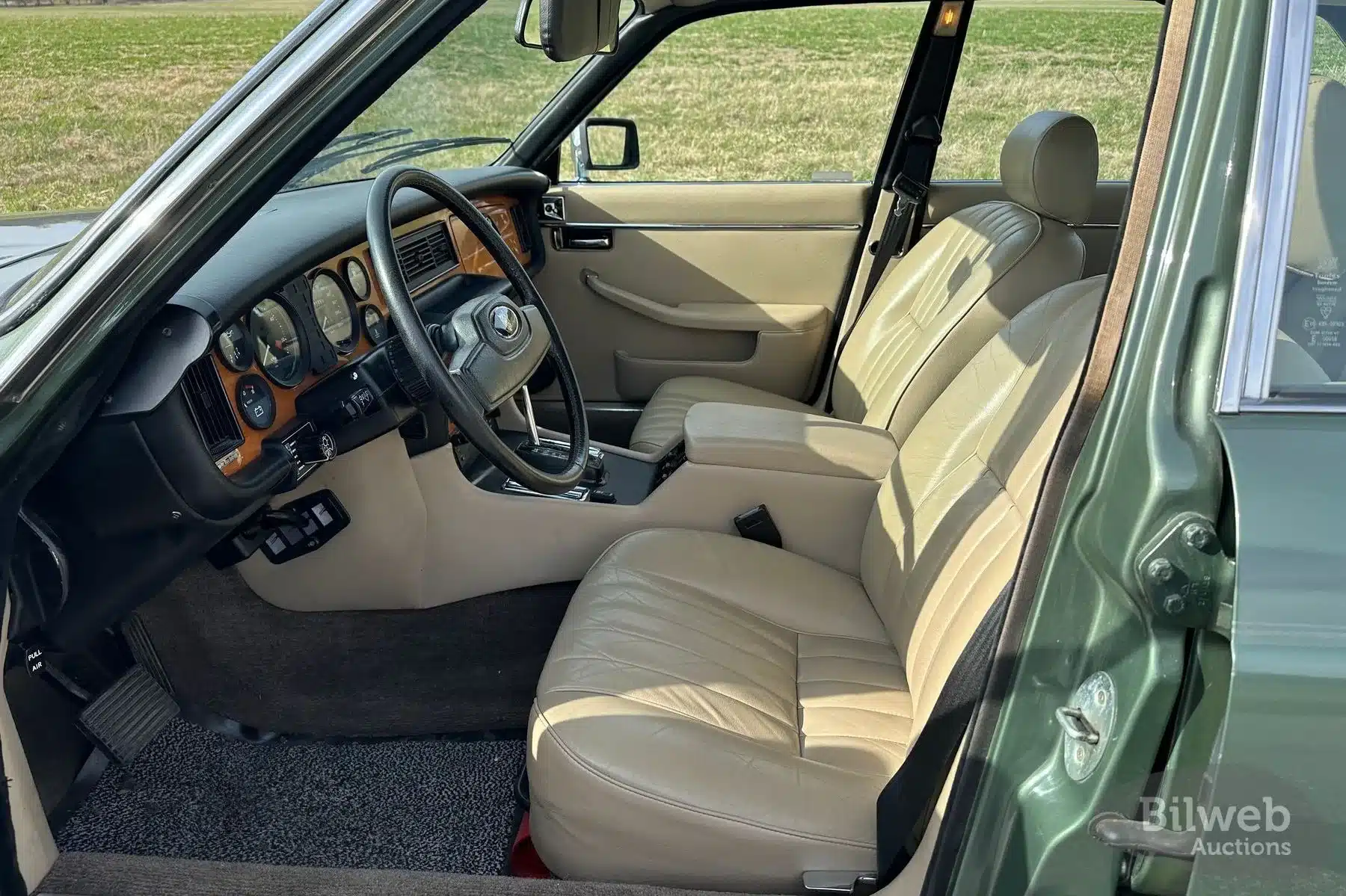 Innenraum eines Jaguar XJ6 Series III von 1985 mit beiger Lederausstattung und Holzelementen.