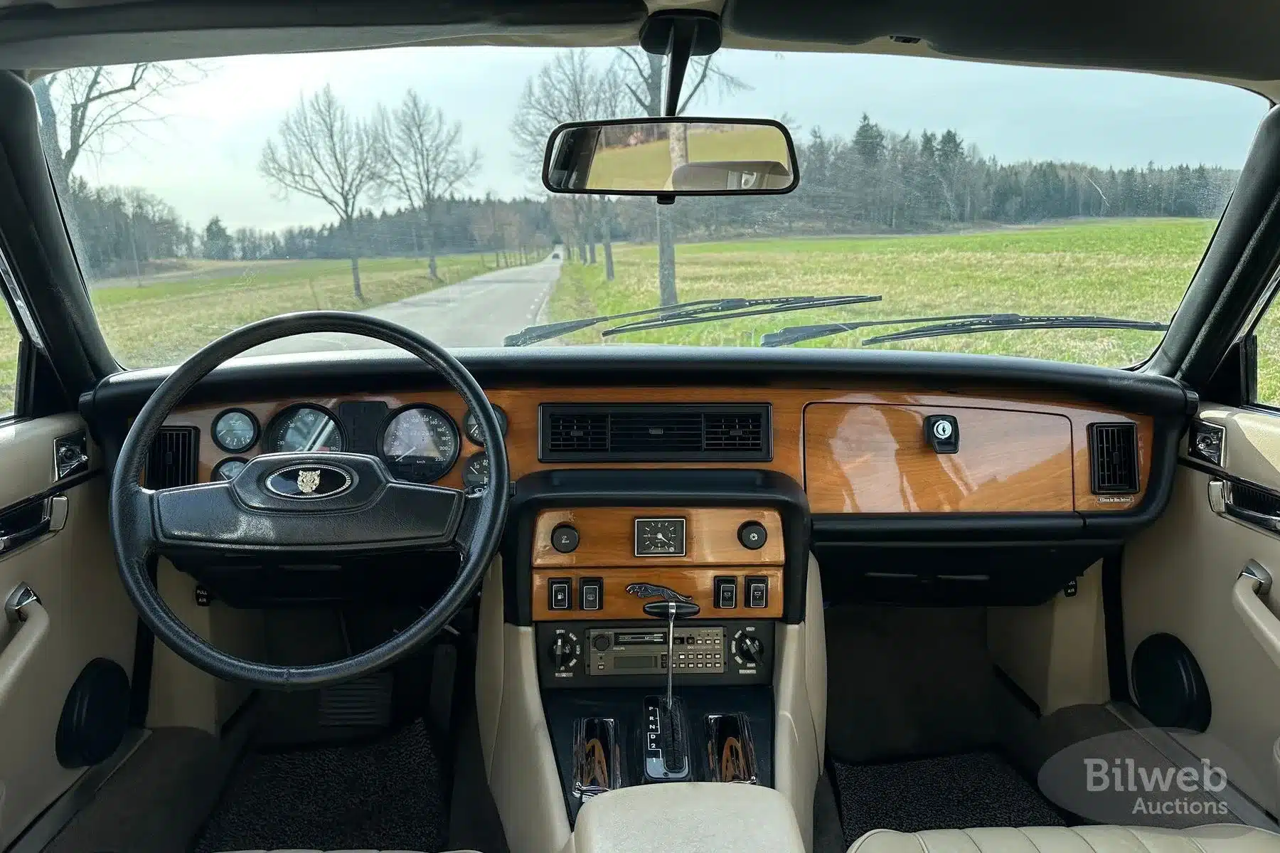 Cockpit und Lenkrad eines Jaguar XJ6 Series III, Baujahr 1985, mit Blick auf Armaturenbrett und Holzausstattung