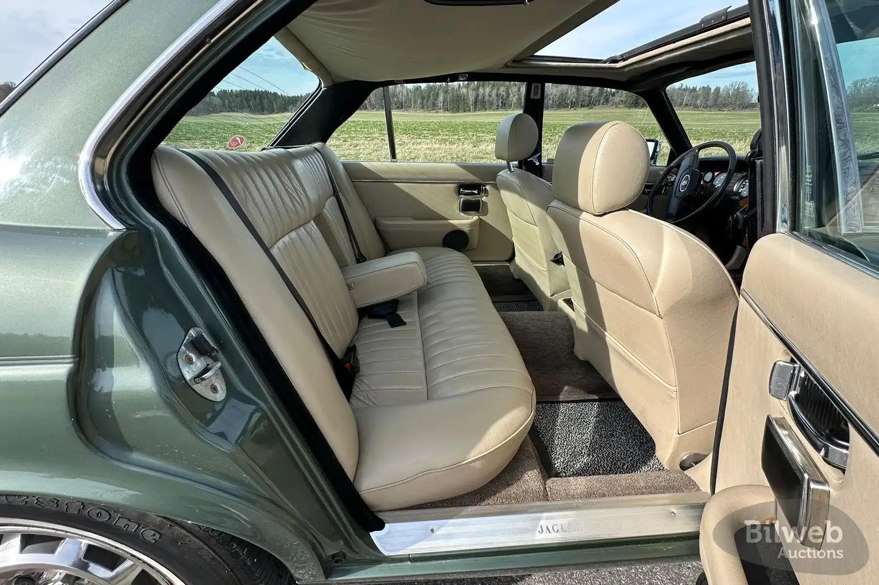 Beiger Innenraum eines Jaguar XJ6 Series III von 1985 mit geöffneter Tür und Schiebedach