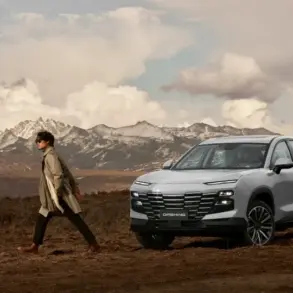 Jetour Dashing SUV steht vor einer Bergkulisse auf unbefestigtem Untergrund, Person läuft neben dem Fahrzeug.