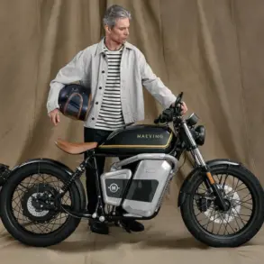 Maeving RM1S Elektromotorrad mit Mann, der einen Helm hält, im Studio