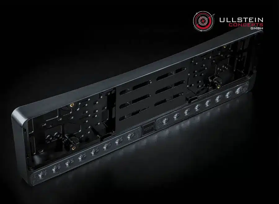 Strands NUUK E-Line DUO Black LED-Kennzeichenhalter mit integrierten LED-Fernlichtern auf schwarzem Hintergrund.