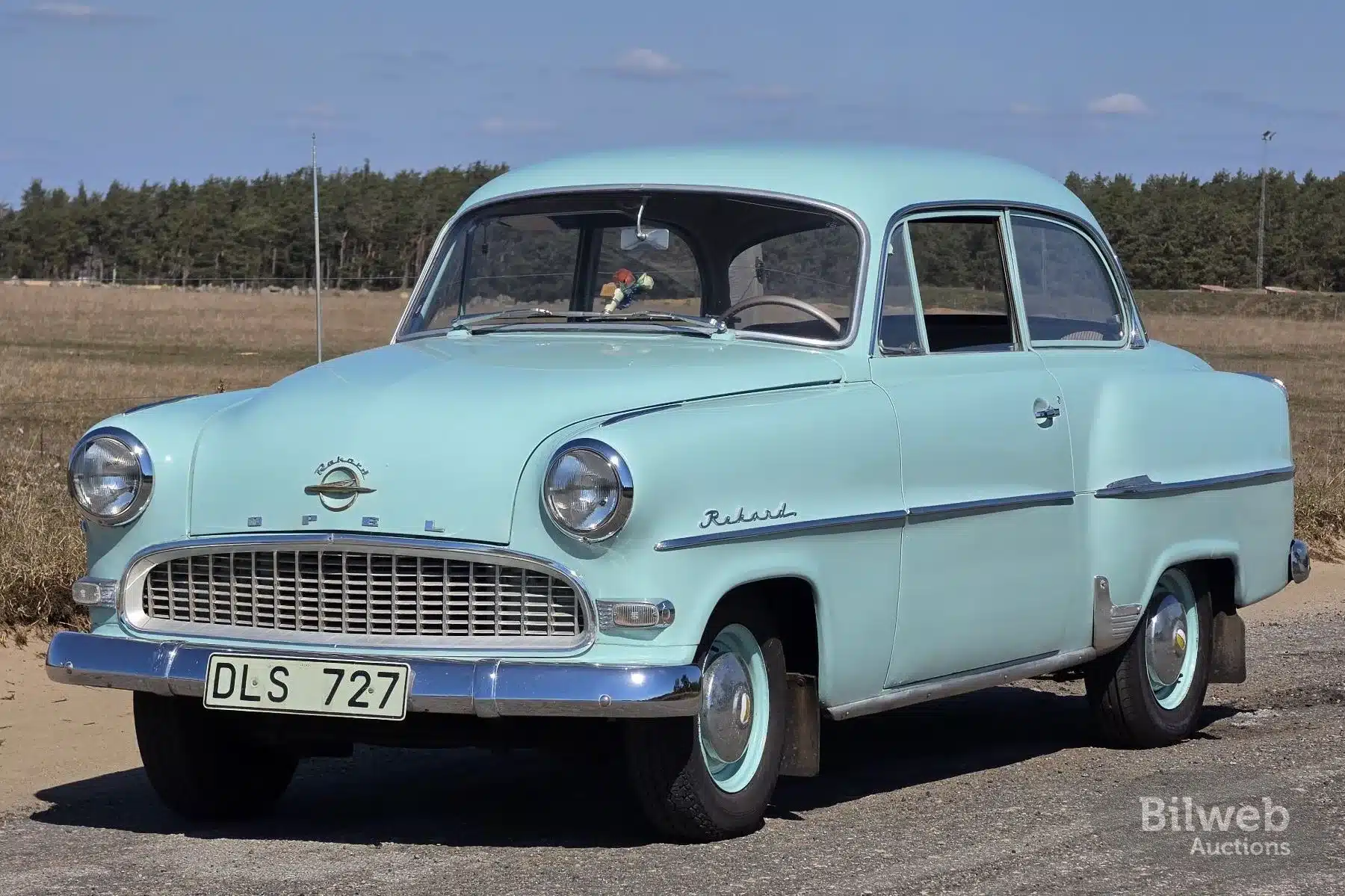 Seitenansicht eines hellgrünen Opel Olympia Rekord 1,5 Limousine von 1956 mit Originaldetails, aufgenommen im Freien