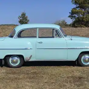 Opel Olympia Rekord 1,5, Baujahr 1956, hellgrün, Seitenansicht auf freiem Feld.
