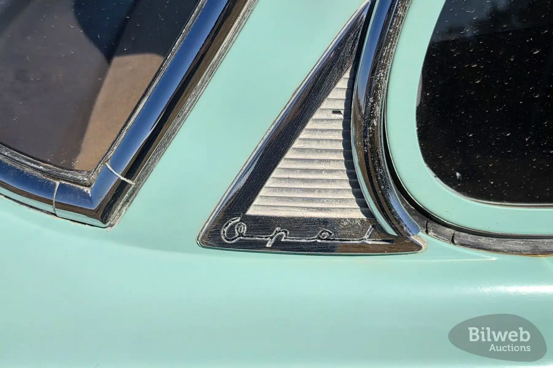 Schriftzug und Karosseriedetail eines Opel Olympia Rekord 1,5 von 1956 in hellgrüner Originallackierung.