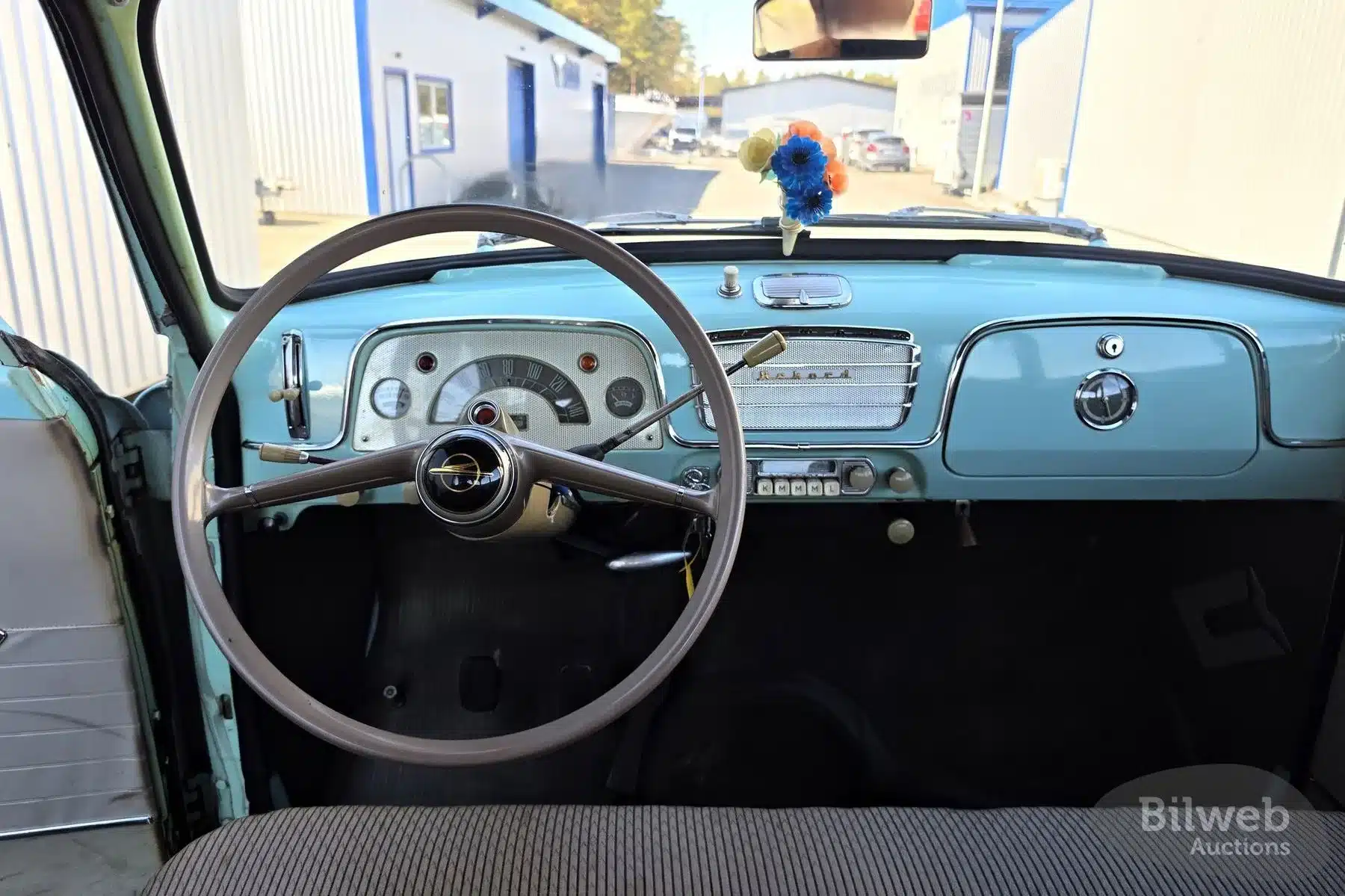 Innenansicht des Opel Olympia Rekord 1,5 von 1956 mit originalem Lenkrad und Armaturenbrett in Pastellblau.