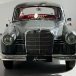 Frontansicht eines Mercedes-Benz 180 Ponton Oldtimers mit glänzendem Lack und rotem Interieur.