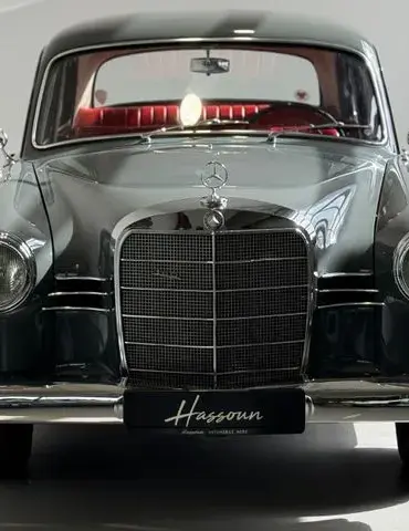 Frontansicht eines Mercedes-Benz 180 Ponton Oldtimers mit glänzendem Lack und rotem Interieur.