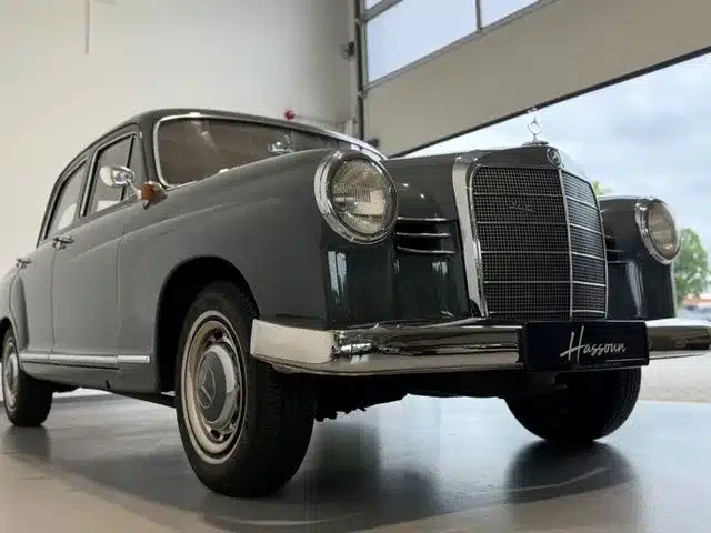 Frontansicht eines grauen Mercedes-Benz 180 Ponton von schräg unten, Oldtimer in heller Garage