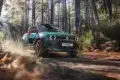 Renault 4 JP4x4 Concept Offroad im Wald, Seitenansicht, offene Türen, Smaragdgrün mit orangefarbenen Akzenten.