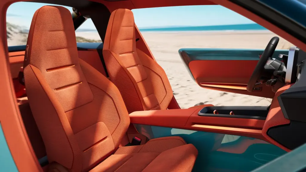 Offener Innenraum des Renault 4 JP4x4 Concept mit orangefarbenen Schalensitzen und Blick auf den Strand.