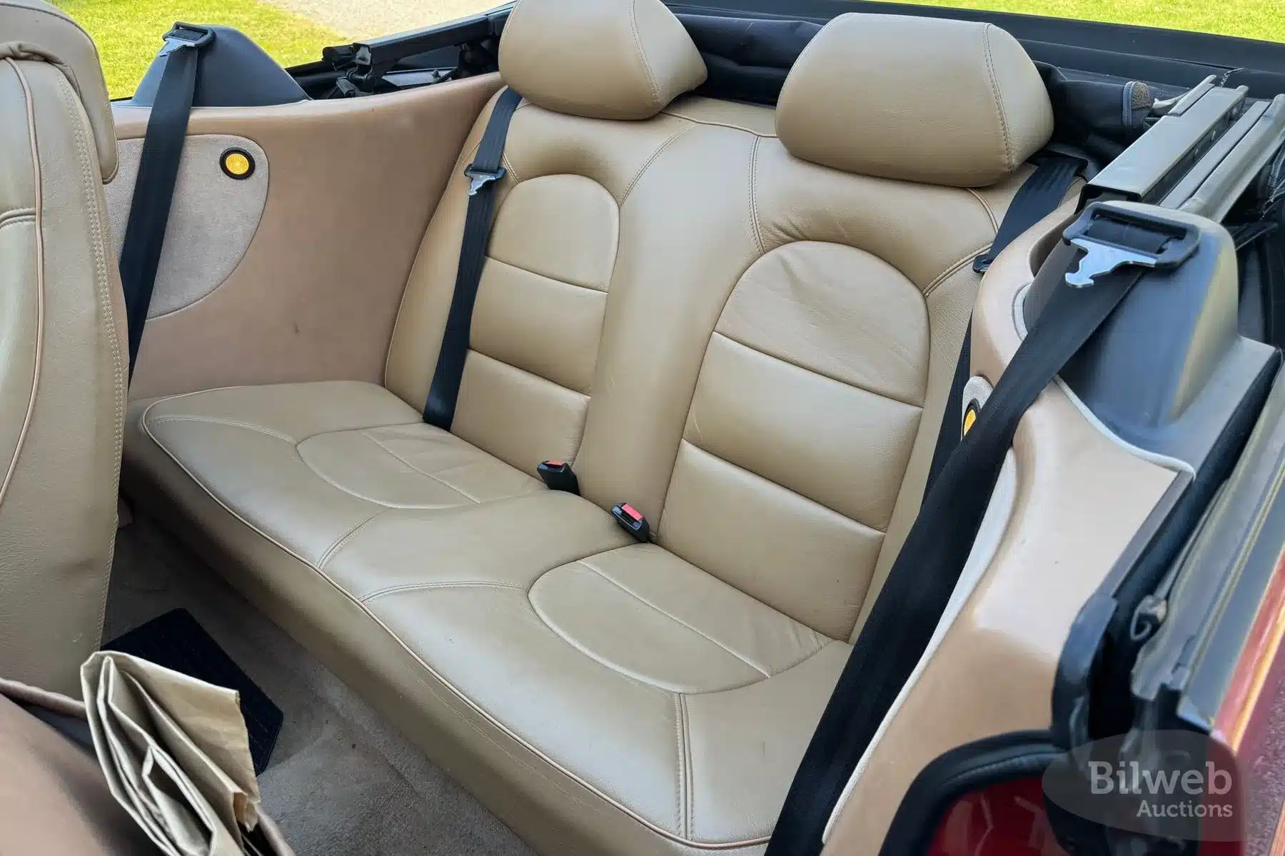 Rückbank eines Saab 900 T16 Cabriolets mit beiger Lederpolsterung und zwei Kopfstützen.