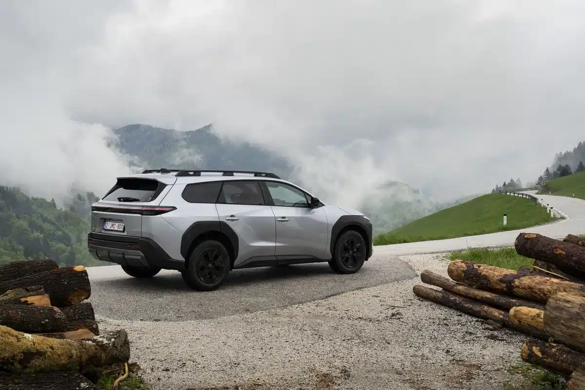 Silberner Toyota bZ4X Touring steht auf einer Gebirgsstraße, umgeben von Nebel und grüner Landschaft