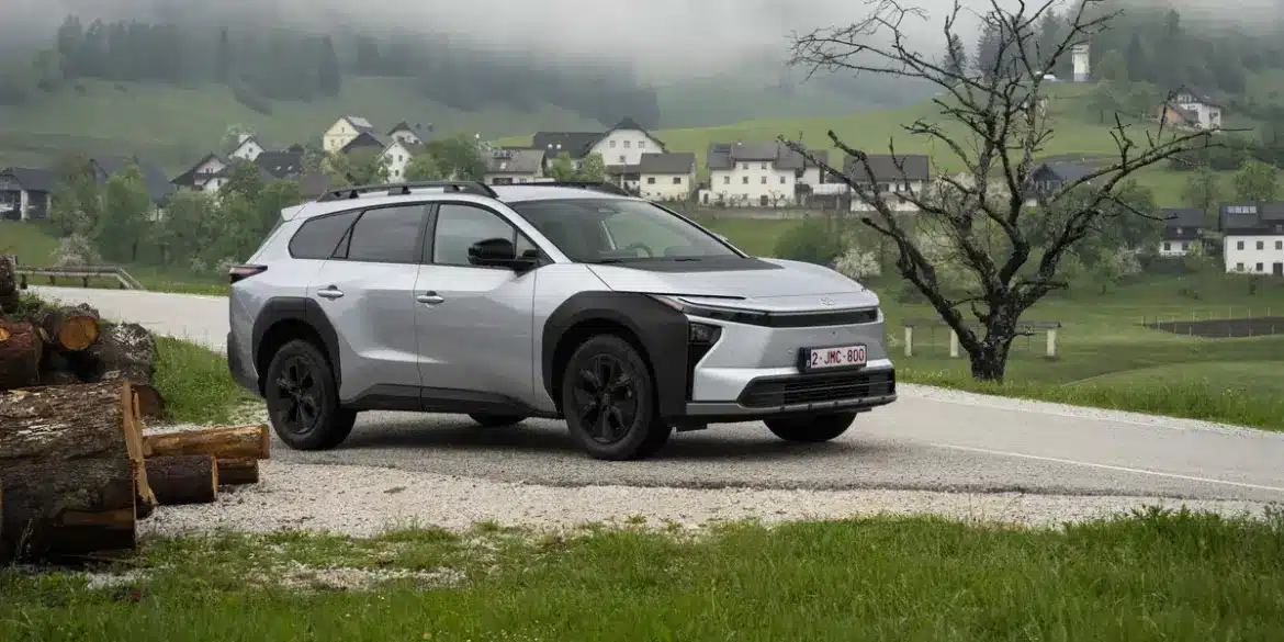 Silberner Toyota bZ4X Touring als Elektro-SUV auf einer Landstraße in bergiger und bewaldeter Umgebung