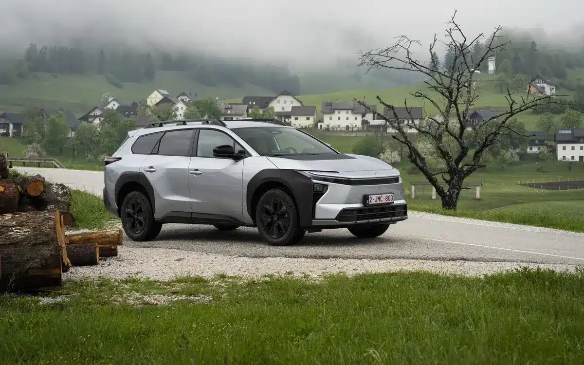 Silberner Toyota bZ4X Touring als Elektro-SUV auf einer Landstraße in bergiger und bewaldeter Umgebung