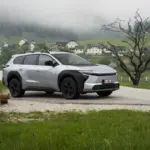 Silberner Toyota bZ4X Touring als Elektro-SUV auf einer Landstraße in bergiger und bewaldeter Umgebung