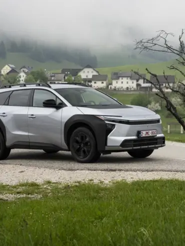 Silberner Toyota bZ4X Touring als Elektro-SUV auf einer Landstraße in bergiger und bewaldeter Umgebung