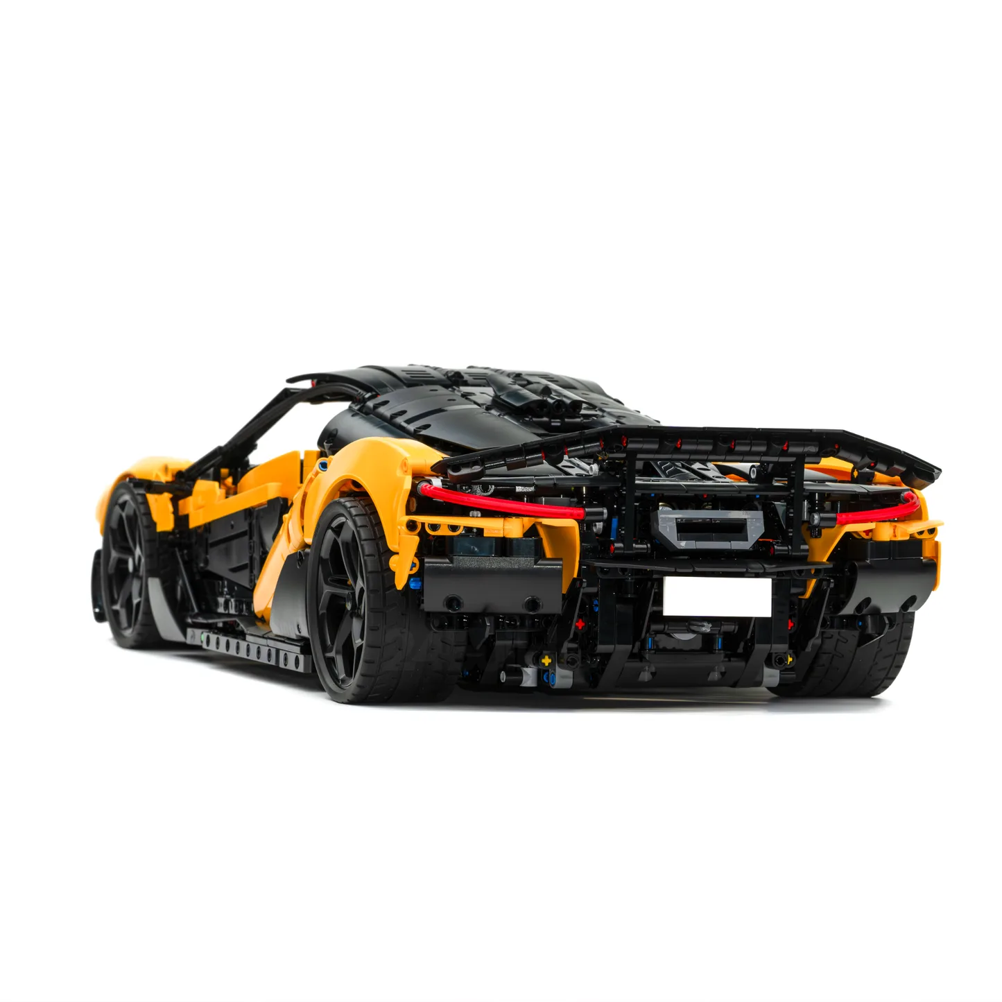 Nahaufnahme eines gelb-schwarzen Hypercar-Technikmodells aus Klemmbausteinen mit sichtbarem Heckspoiler und Fahrwerksdetails.
