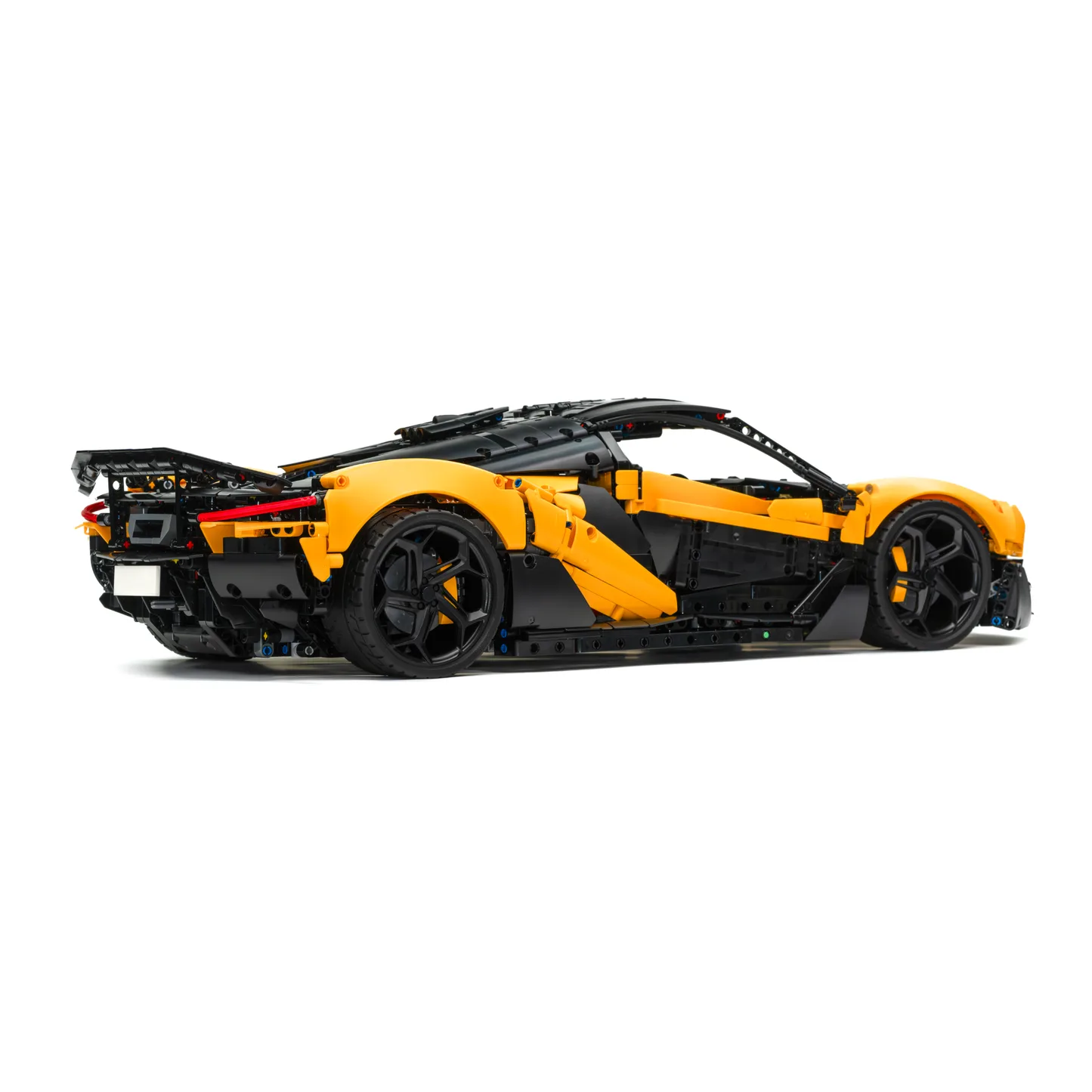 Technikbausatz eines gelben Hypercars aus Klemmbausteinen, Seitenansicht mit Sicht auf den Heckspoiler