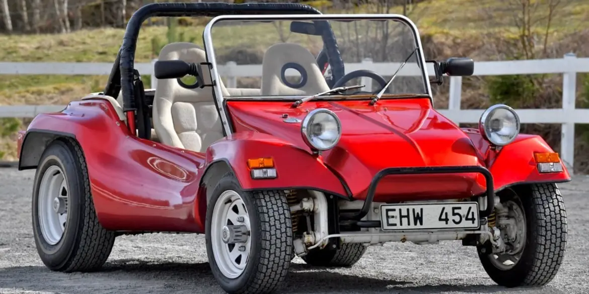 Roter Beach Buggy 1300, offener Umbau auf VW Käfer-Basis, mit weißen Speichenrädern und Überrollbügel, stehend im Freien.