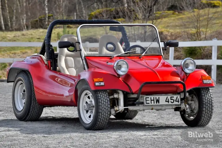 Roter Beach Buggy 1300, offener Umbau auf VW Käfer-Basis, mit weißen Speichenrädern und Überrollbügel, stehend im Freien.