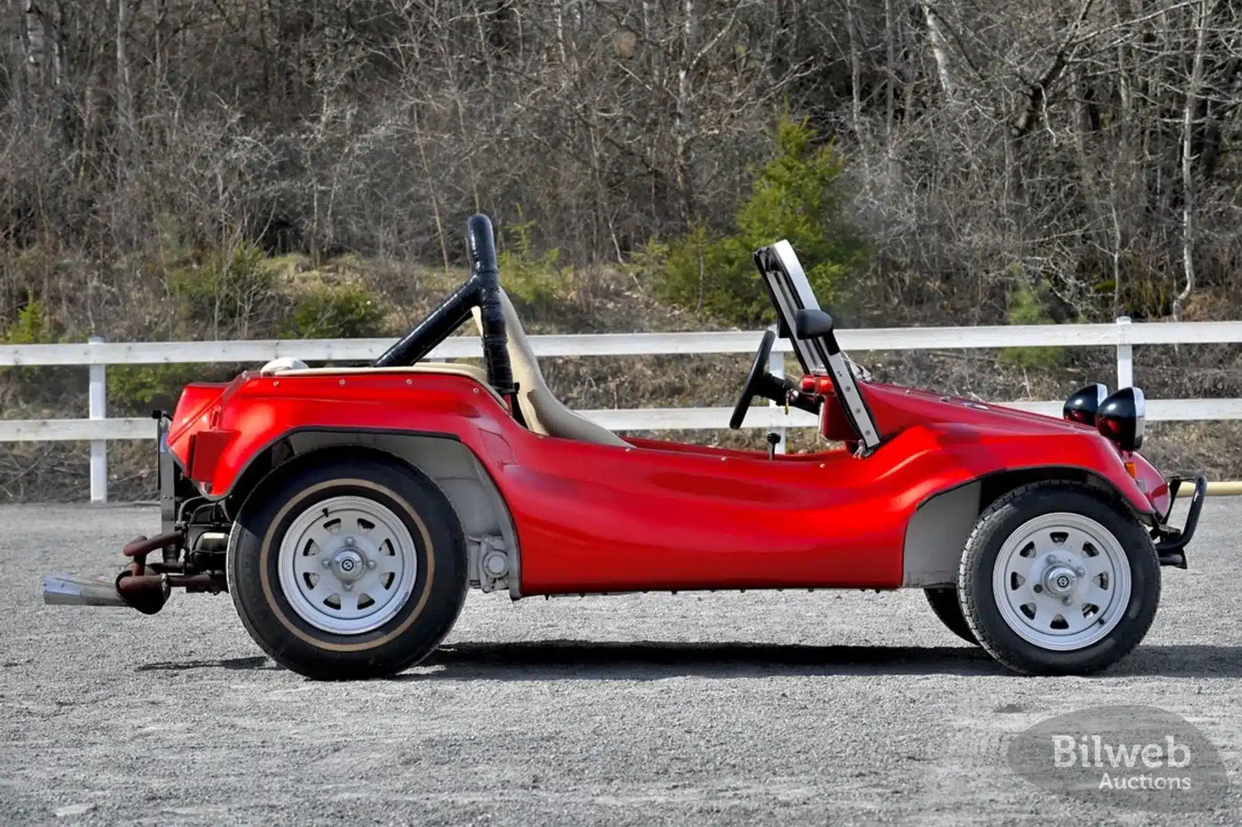 Seitenansicht eines roten Beach Buggy 1300, umgebaut auf Basis eines VW Käfers, mit weißem Überrollbügel und weißen Felgen.