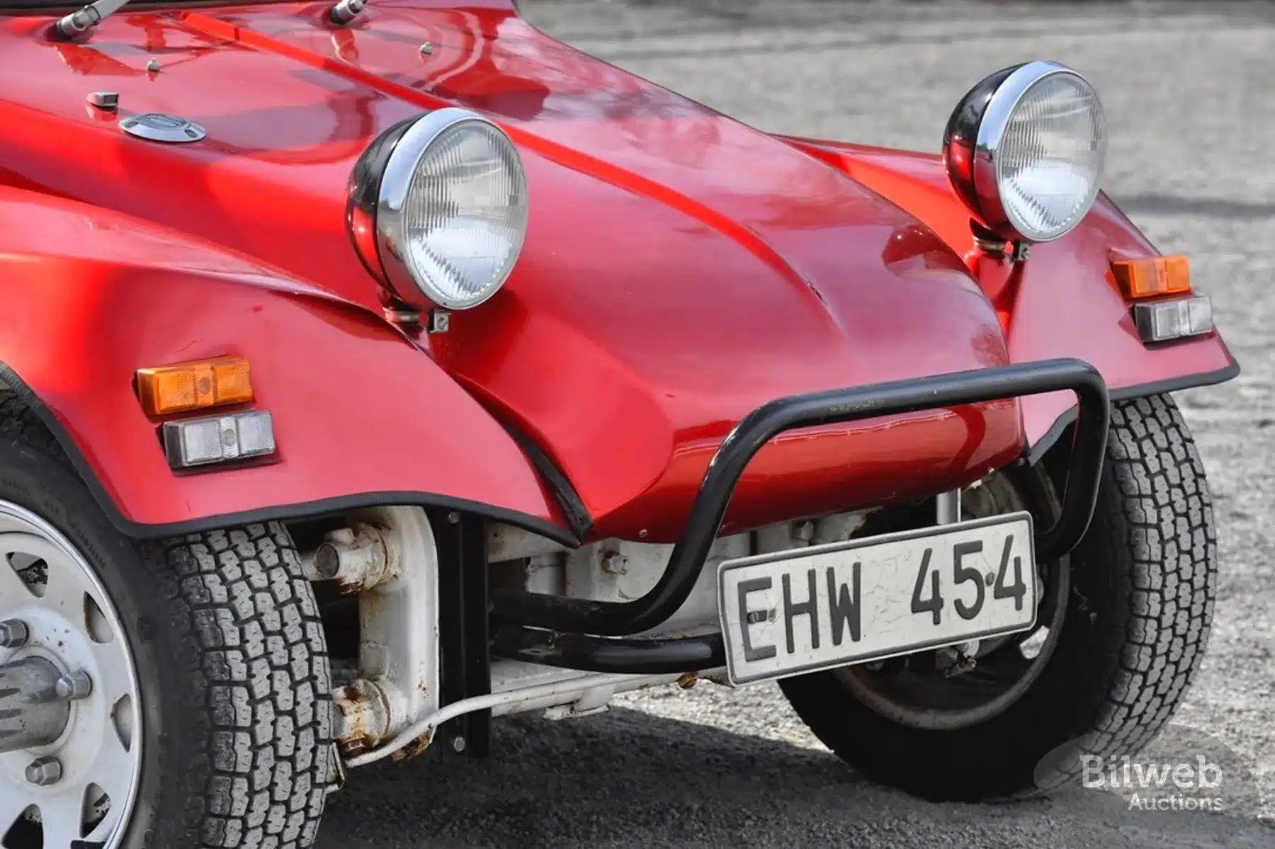 Frontpartie eines rot-metallic Beach Buggy 1300 mit typischen 80er-Jahre-Details wie runde Scheinwerfer, weißen Speichenrädern und schwarzem Rammschutz