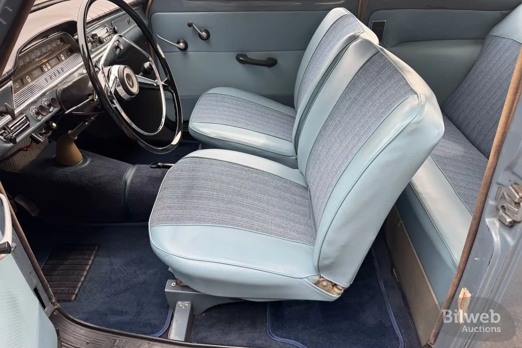 Restaurierter Innenraum eines Volvo PV 544 B18 von 1961 mit blauen Sitzen und originalem Armaturenbrett.
