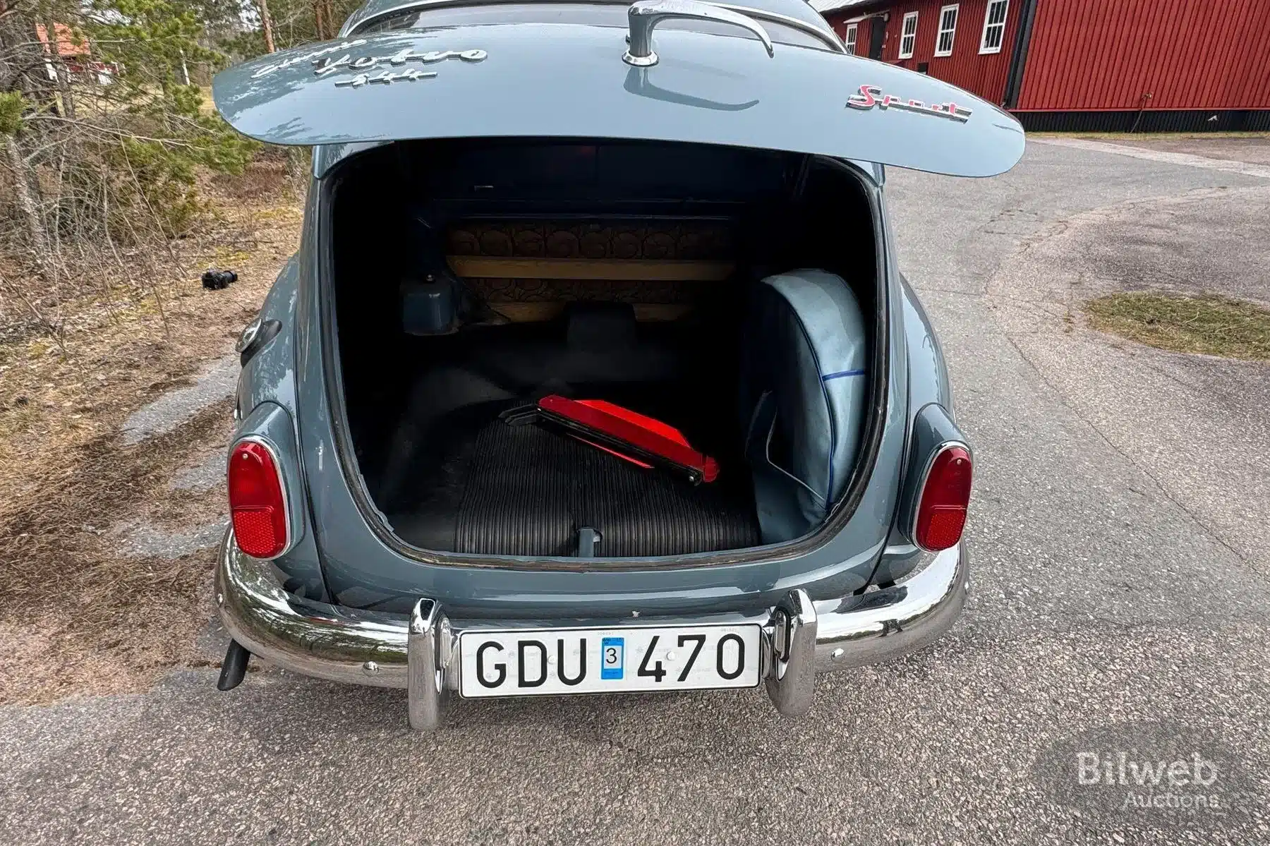 Geöffneter Kofferraum eines Volvo PV 544 B18 von 1961 mit Ersatzrad und Warndreieck.