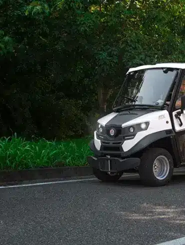 ATX ED Double Cab Elektro-Nutzfahrzeug mit Doppelkabine auf einer Straße vor grünem Hintergrund