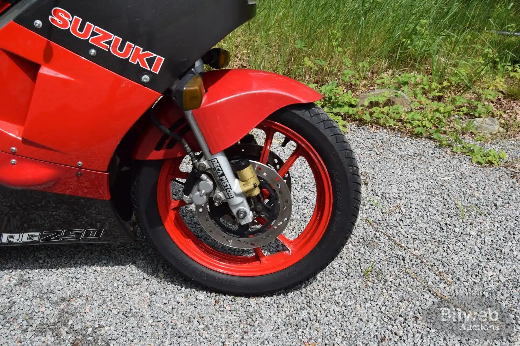 Nahaufnahme des Vorderrads einer Suzuki RG 250 Gamma mit sichtbarer Bremsanlage und Gabel