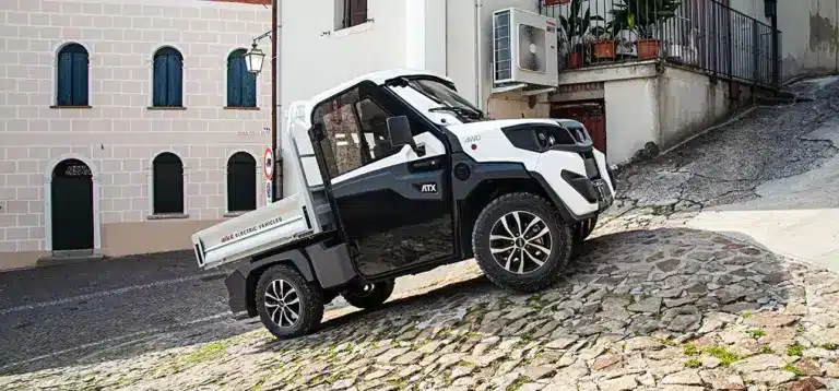 Alkè ATX 480 Elektro-Nutzfahrzeug fährt eine steile, gepflasterte Straße hinauf