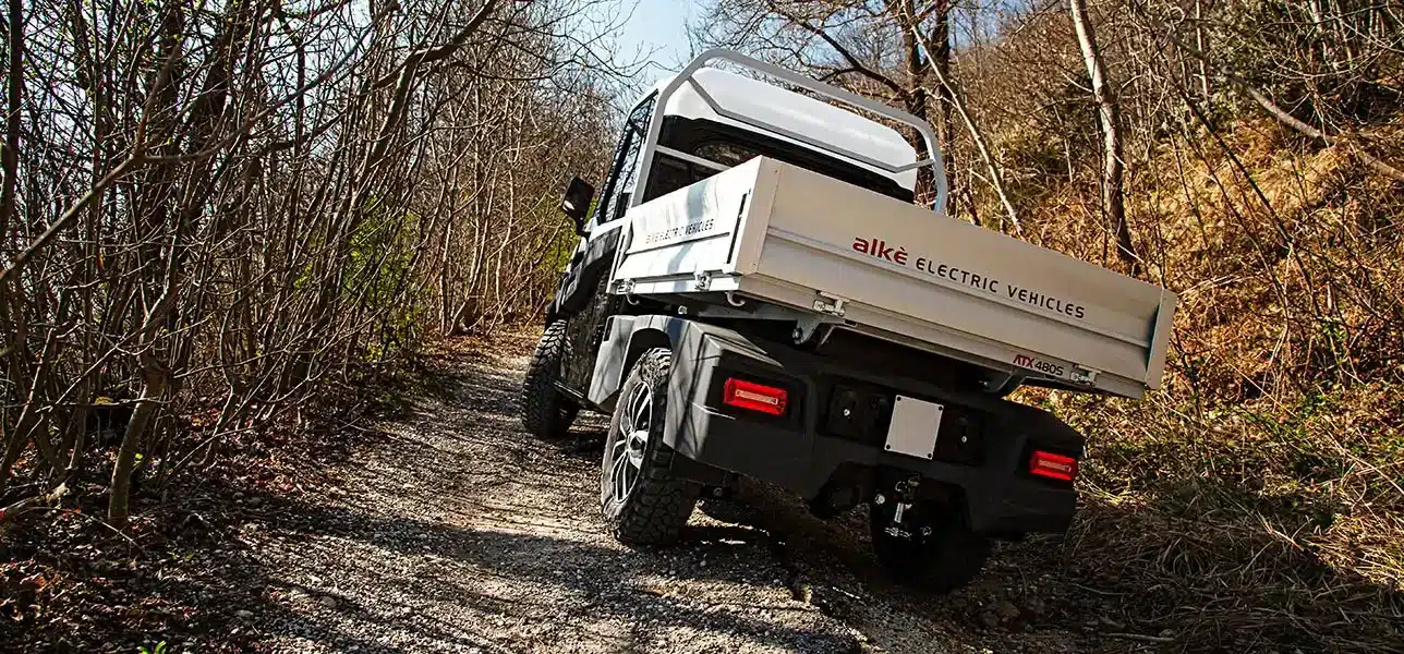 Alkè ATX 480 Elektrotransporter auf einem Waldweg im Offroad-Betrieb, Kies und Steigung.