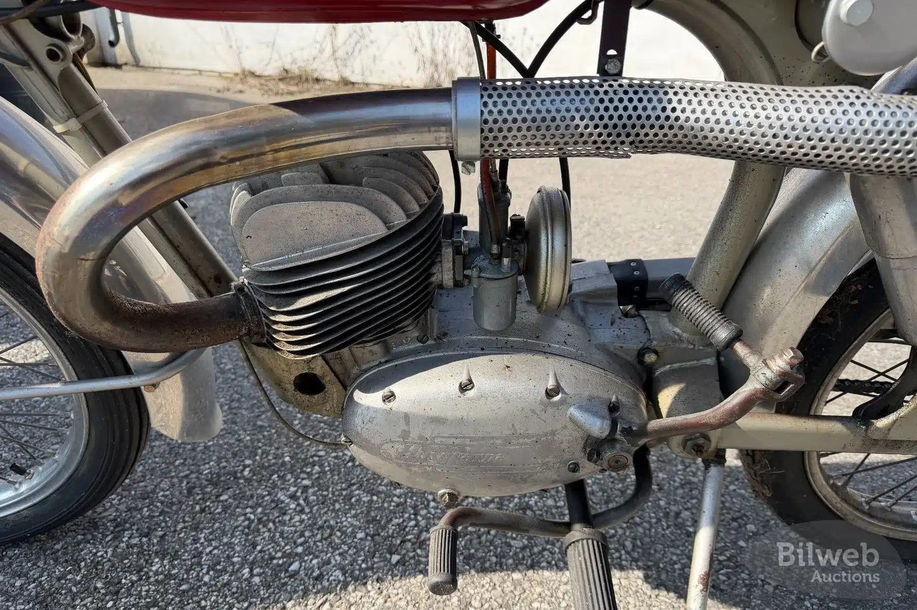 Nahaufnahme des Motors und Auspuffs einer Husqvarna 282 E Silverpil (1960) mit Patina und Alterserscheinungen.
