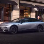 Der XPENG P7+ in Silber geparkt vor einem Straßencafé.