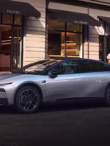 Der XPENG P7+ in Silber geparkt vor einem Straßencafé.
