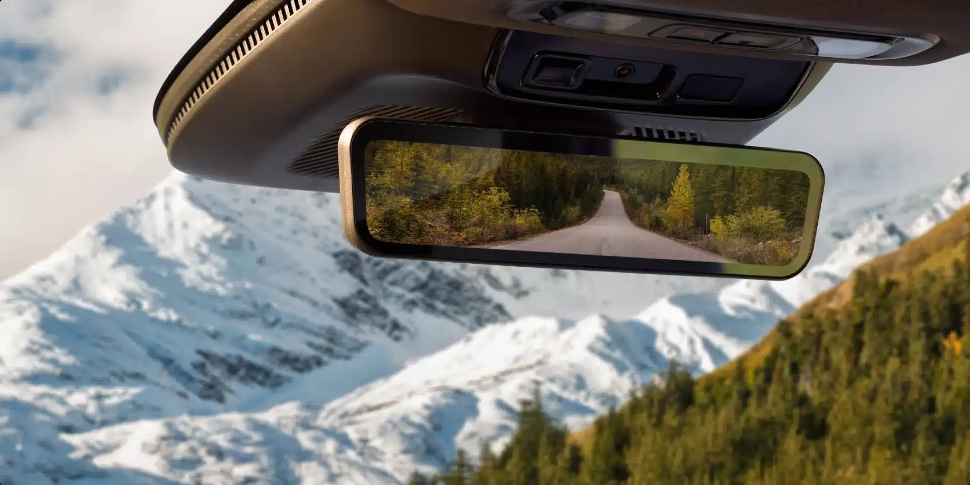 Digitaler Rückspiegel mit Blick auf eine Straße und Gebirgslandschaft