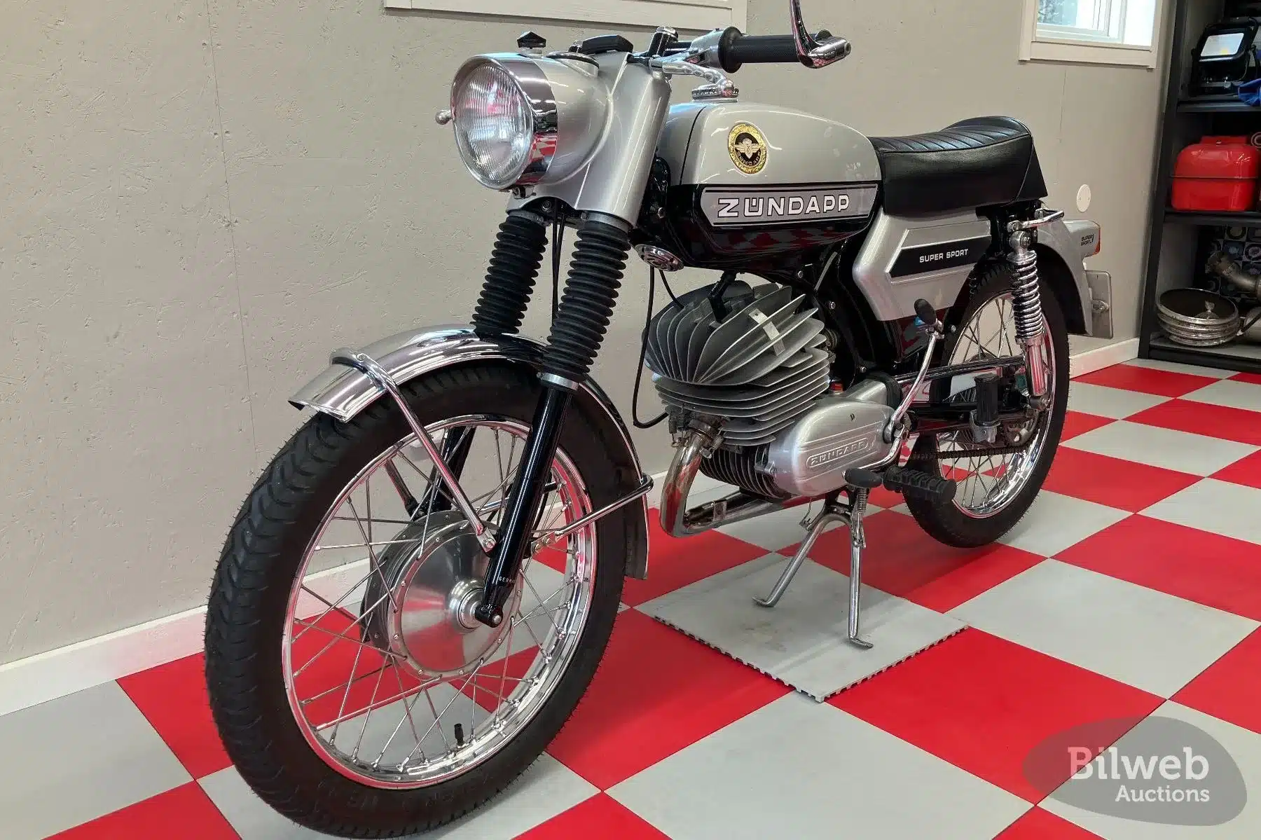 Silber-schwarze Zündapp KS 125 von 1970 als Café Racer auf rot-grau kariertem Boden präsentiert