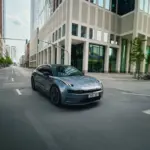 ZEEKR 001, grauer Elektro-Shooting Brake, fährt durch eine Innenstadt mit modernen Gebäuden.