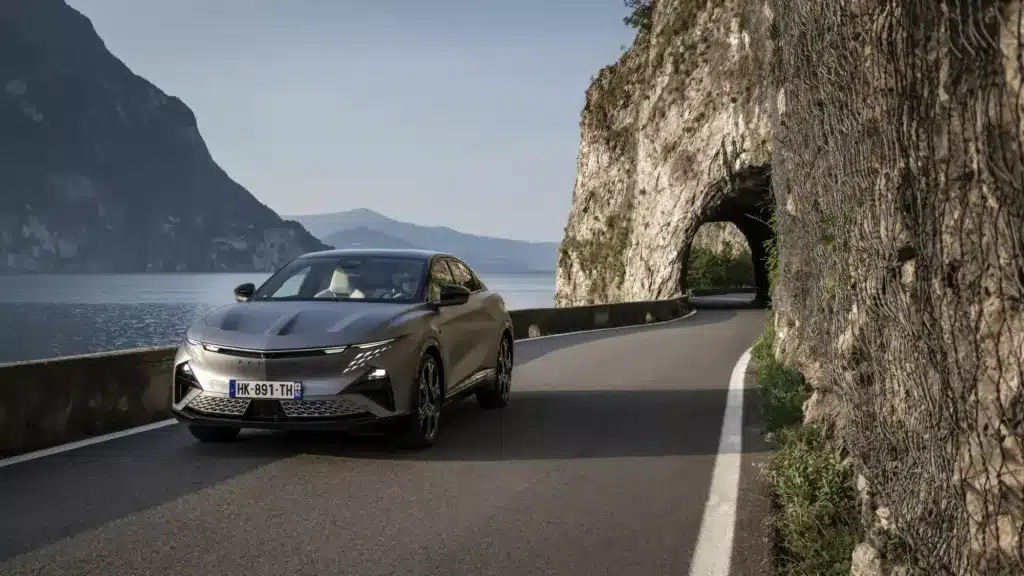 Alpine A390 GTS fährt auf einer kurvigen Bergstraße neben einem See und Felsen