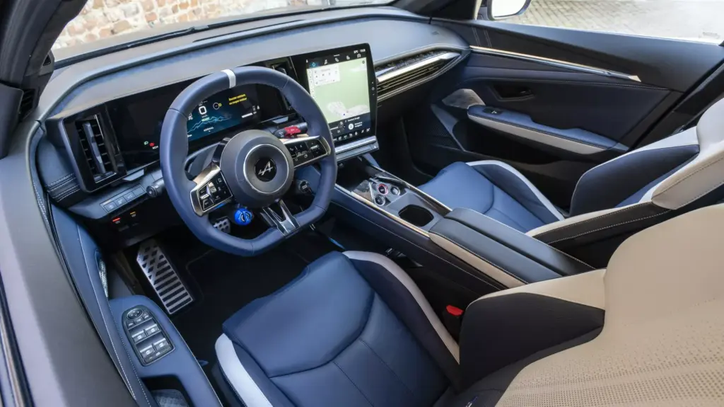 Innenraum und Cockpit der Alpine A390 GTS mit sportlichem Lenkrad und großem Touchscreen.