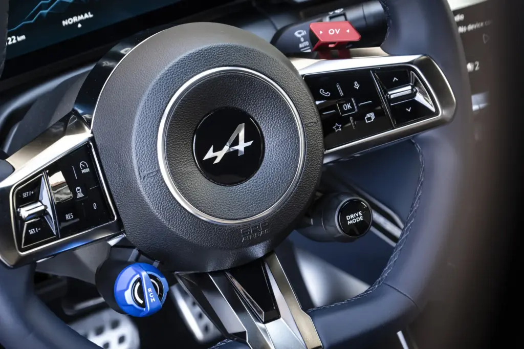 Detailansicht des Sportlenkrads mit Alpine-Logo und Bedienknöpfen in der Alpine A390 GTS.